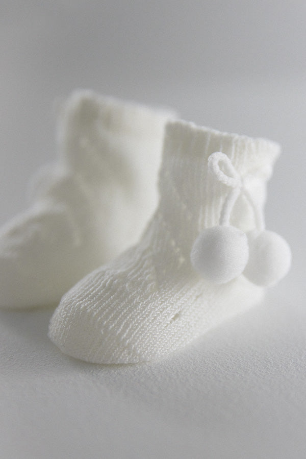 Calcetines perlé con borlas recién nacido marfil